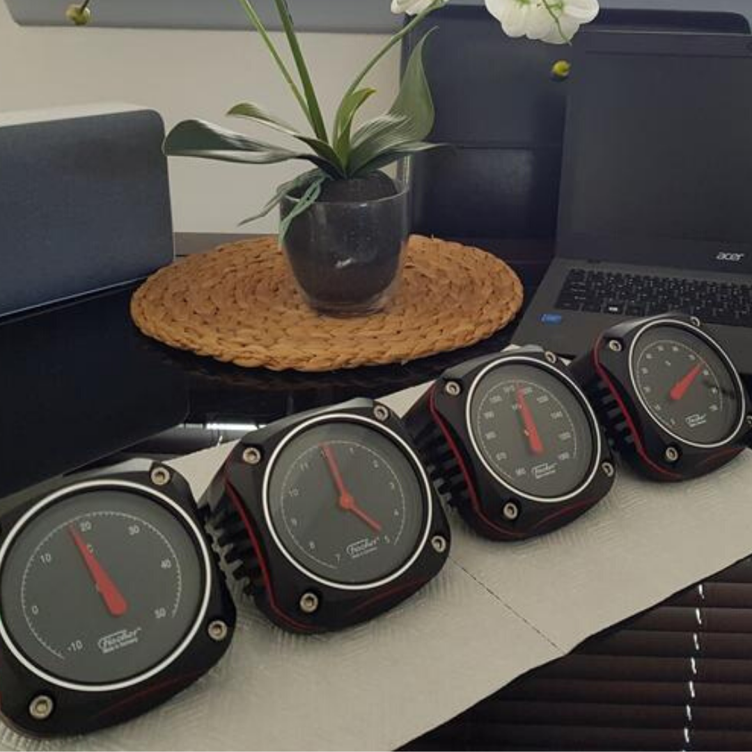 Set of four German-made weather instruments: barometer, thermometer, hygrometer, tide clock on table.