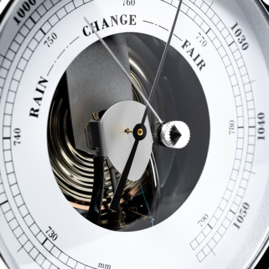 Close-up of analog German barometer dial with rain, change, and fair weather readings