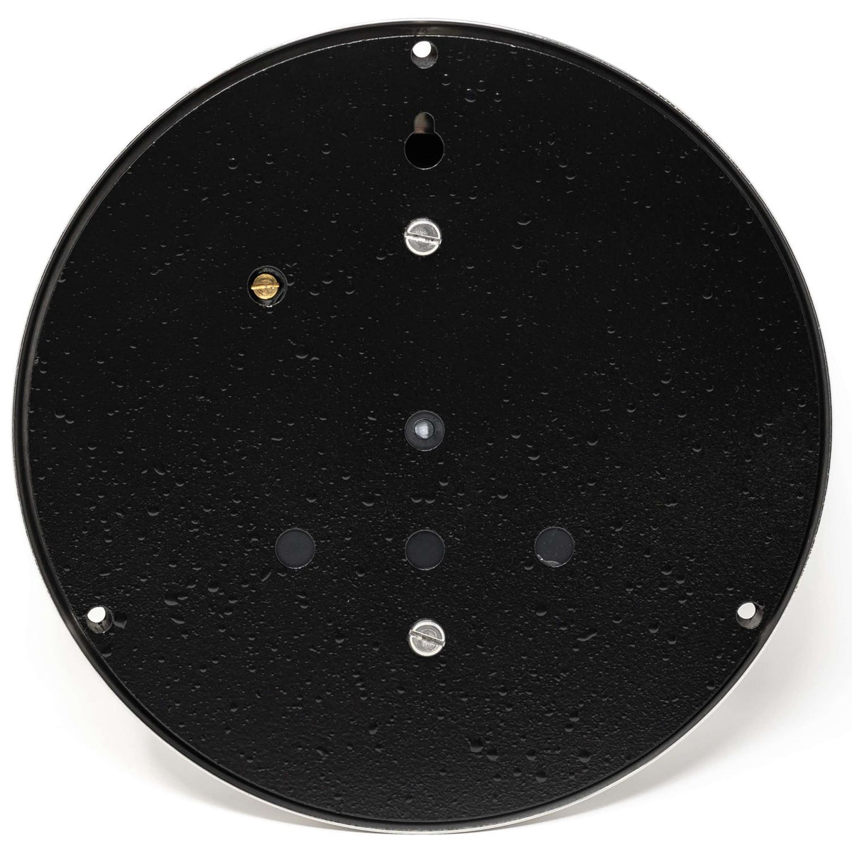 Back of round black barometer or clock with visible mounting holes and water droplets