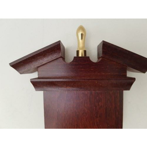 Close-up of wooden barometer or clock case top with brass finial, German weather instrument