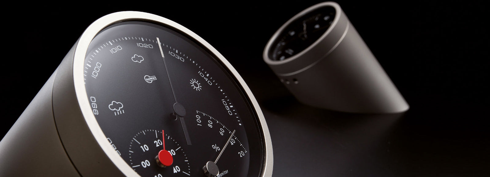 Modern German-made barometer and hygrometer, close-up on sleek black dials